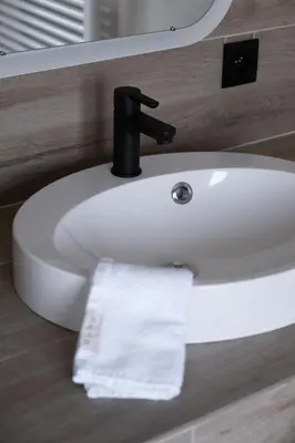 a bathroom sink with a white towel on it at B&B De Joker in Turnhout