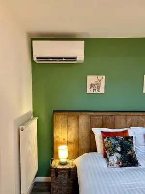 a bedroom with a bed with a green wall at B&B De Joker in Turnhout