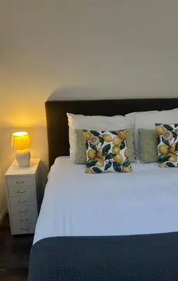 a bed with pillows and a lamp on a night stand at B&B De Joker in Turnhout