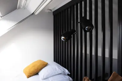 a bedroom with a bed with a black headboard at B&B De Joker in Turnhout