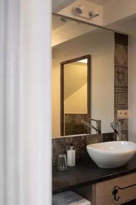 a bathroom with a sink and a mirror at B&B De Joker in Turnhout