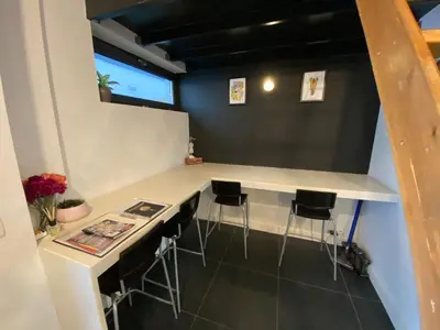 a kitchen with a counter and stools in a room at Modern cozy studio with backyard in Antwerp