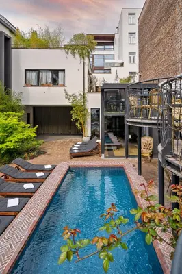 a backyard with a swimming pool and a house at Latroupe Hotel Le Berger in Brussels