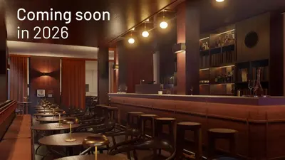 a restaurant with a row of tables and a bar at Latroupe Hotel Le Berger in Brussels