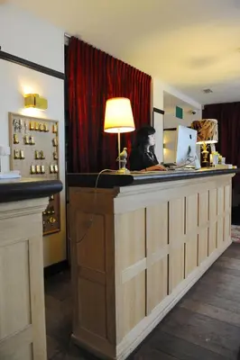 a woman sitting at a counter with a laptop at Latroupe Hotel Le Berger in Brussels