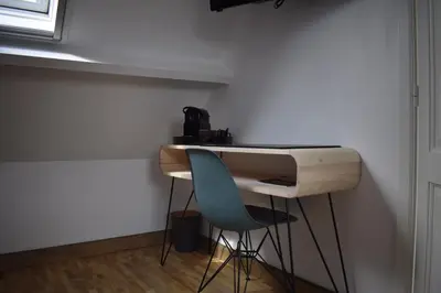 a desk with a blue chair next to a wall at De Pauw B&B in Zele