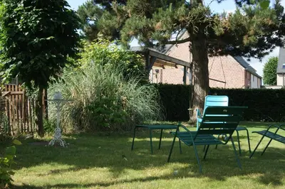 a group of chairs and a table in a yard at De Pauw B&B in Zele