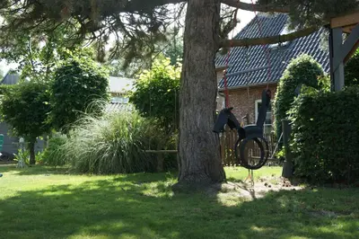 a bike chained to a tree in a yard at De Pauw B&B in Zele