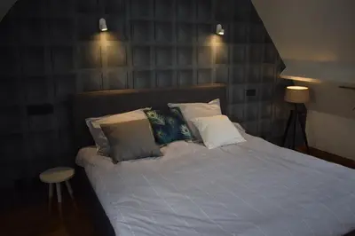 a bedroom with a bed with white sheets and pillows at De Pauw B&B in Zele
