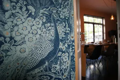 a peacock pattern on a wall in a dining room at De Pauw B&B in Zele
