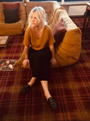 a woman sitting on the floor next to a couch at A Place Antwerp - Boutique Suites & Flats - Vrijdagmarkt 1 in Antwerp