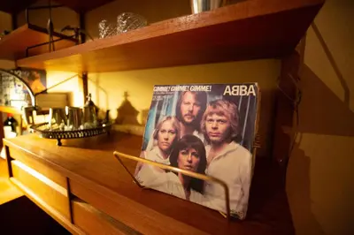 a dvd of the abba movie on a wooden shelf at A Place Antwerp - Boutique Suites & Flats - Vrijdagmarkt 1 in Antwerp
