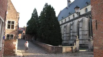 a man walking in an alley next to a building at Hotel Guesthouse Begijnhof in Leuven