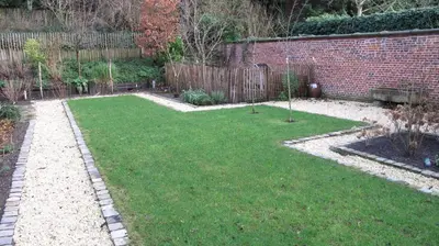 a garden with a brick wall and green grass at Hotel Guesthouse Begijnhof in Leuven