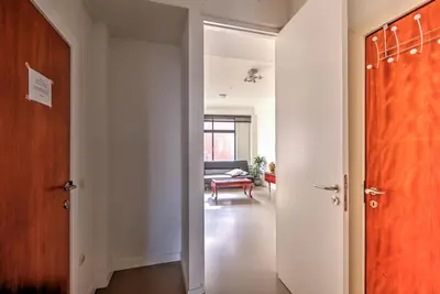 a hallway with an open door and a living room at The Meir Lodge. Apartments in heart of Antwerp in Antwerp