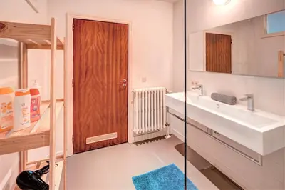 a bathroom with a sink and a wooden door at The Meir Lodge. Apartments in heart of Antwerp in Antwerp