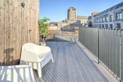 a balcony with a white chair and a fence at The Meir Lodge. Apartments in heart of Antwerp in Antwerp
