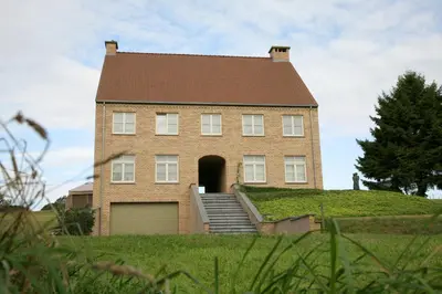 a large brick house on a hill with a garage at B&B Vallis Dyliae in Korbeek-Dijle