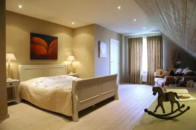 a bedroom with a bed with a horse toy in the foreground at B&B Vallis Dyliae in Korbeek-Dijle