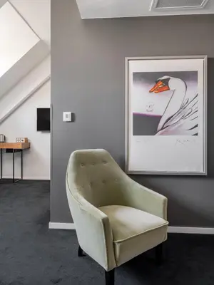 a living room with a chair and a picture of a swan at Numa Brussels Lief in Brussels