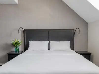a bedroom with a large bed with white sheets and flowers at Numa Brussels Lief in Brussels
