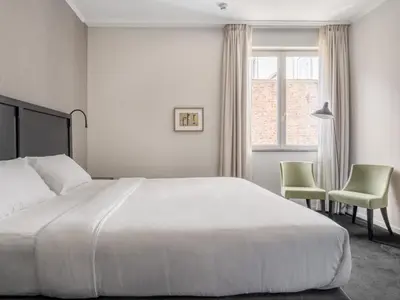a bedroom with a large white bed and two chairs at Numa Brussels Lief in Brussels