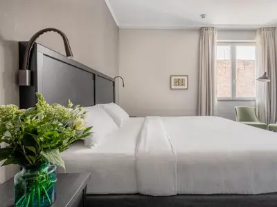 a bedroom with a white bed and a vase of flowers at Numa Brussels Lief in Brussels