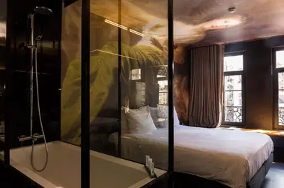 a bedroom with a shower and a bed and a tub at HotelO Kathedral in Antwerp