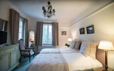 a bedroom with a large bed and a chandelier at Hotel Hippocampus in Mol