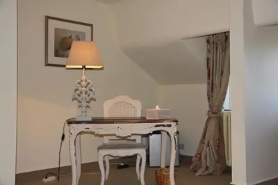 a white table with a chair and a lamp at Hotel Hippocampus in Mol