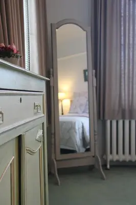 a mirror in a room with a bed and a bedroom at Hotel Hippocampus in Mol