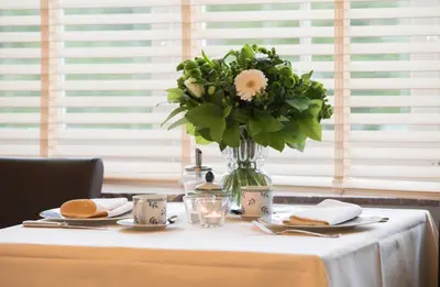 a table with a vase of flowers on it at Hotel Hippocampus in Mol
