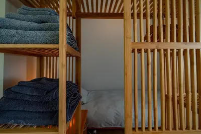 a wooden bunk bed with blue towels on it at Guest house Huize De Wit in Keerbergen