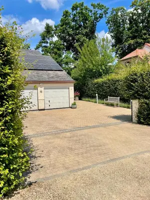 a white garage with a bench in front of it at Guest house Huize De Wit in Keerbergen