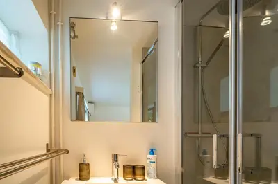 a bathroom with a shower and a sink with a mirror at Guest house Huize De Wit in Keerbergen