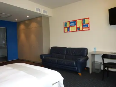 a hotel room with a bed and a couch at Hotel De Swaen in Herentals