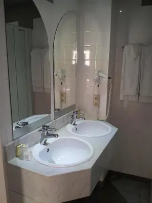 a bathroom with two sinks and a large mirror at Hotel De Swaen in Herentals