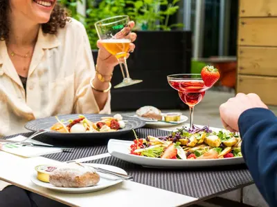 a group of people sitting at a table with plates of food at Thon Hotel EU in Brussels
