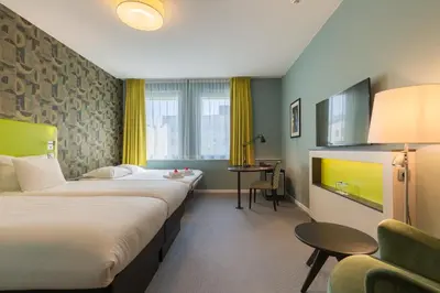a hotel room with two beds and a chair at Thon Hotel EU in Brussels