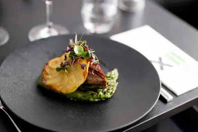 a black plate with a piece of food on a table at Thon Hotel EU in Brussels