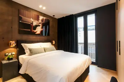 a bedroom with a large white bed and a window at Kaai11 - Riverview Lofts & Suites in Antwerp