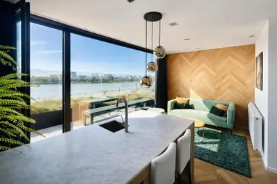 a kitchen with a large window with a view of the water at Kaai11 - Riverview Lofts & Suites in Antwerp