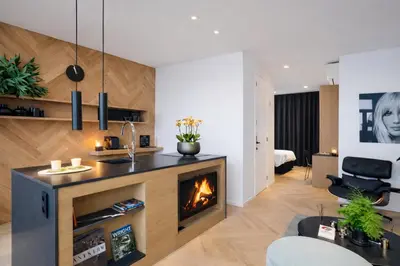 a living room with a fireplace and a bedroom at Kaai11 - Riverview Lofts & Suites in Antwerp