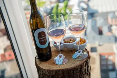 two glasses of wine sitting on a stump next to a window at Exclusieve privé wellness penthouse SkyNooz in Antwerp