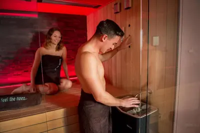 a man standing in a sauna with a woman at Exclusieve privé wellness penthouse SkyNooz in Antwerp