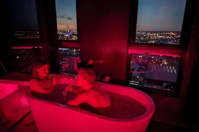 a man and woman in a bath tub in a room with a view at Exclusieve privé wellness penthouse SkyNooz in Antwerp