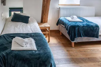 a room with two beds with towels on them at B&B La Ferme de l'Hosté in Wavre