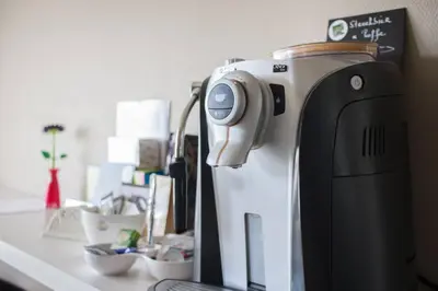 a coffee maker sitting on top of a desk at Guesthouse De Steenberg tweepersoonskamer met grote badkamer, kitchenette en tuinzicht op de eerste verdieping in Geel