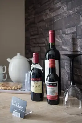 two bottles of wine sitting on a table at Guesthouse De Steenberg tweepersoonskamer met grote badkamer, kitchenette en tuinzicht op de eerste verdieping in Geel