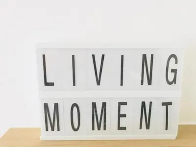 a sign that says living moment on a white wall at LivingTheMoment in Ghent